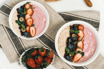 Presented by fruits putting yogurt toppings with strawberry, berry, oats, raisins and chia seed...