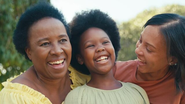 Loving three generation female family laughing and hugging outdoors in countryside together - shot in slow motion