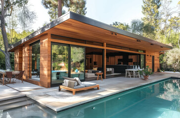 A midcentury modern style pool house with large windows and sliding doors, surrounded by an outdoor seating area with chairs, a table, and plants.  - obrazy, fototapety, plakaty