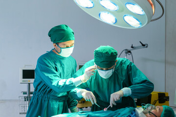 Medical team performing a surgical operation in operating Room, Concentrated surgical team...