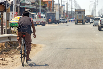 A man rides a road bike on a highway in the city center, Bangkok, Thailand