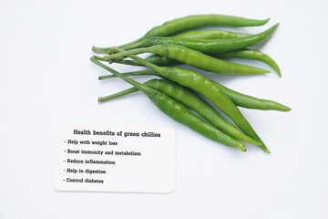 Green chillies with tag of text Health benefits of green chillies. White background. Concept,...