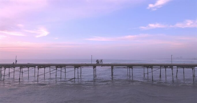 Aerial view of beauty sunset over the sea and dock with artisanal fishermen. Puerto Eten, Peru. 