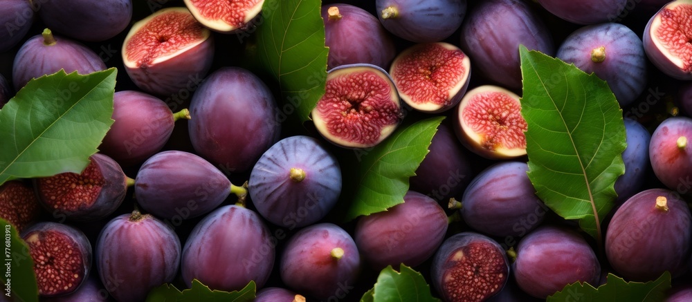 Poster A close up of several ripe figs clustered together, each adorned with green leaves, perfect for food or health-themed concepts