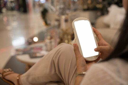 Close-up image of girl sitting in the cafe and using mobile phone. smartphone white screen mockup for display graphic banner.