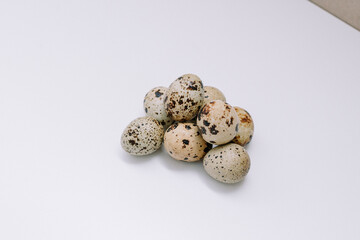 Obraz premium Quail eggs that are the size of an adult human's thumb are lined up on a white mat for photographic and detailed purposes.