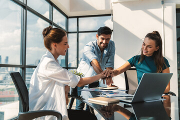 Group of skilled businesspeople putting hands together at modern office.Happy smart business team...