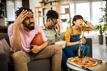 Multiracial group of friends watching rugby. Angry because their team is losing.