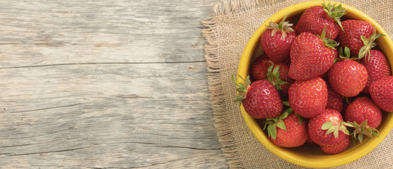 Juicy, ripe strawberry close-up. Panorama, Copy space. Wooden background. Generated by artificial...