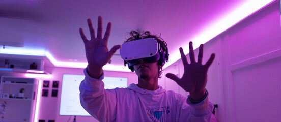 A teenager in vr glasses playing video games with virtual reality headset, trying to touch something with hand. Concept of digital metaverse and cyber world technology.