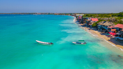 Aerial view of Playa Blanca, Baru, with turquoise waters, boats, and colorful beachfront structures