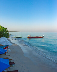 Playa Blanca in Baru, Cartagena, Colombia with anchored boats and lush island backdrop on a clear...