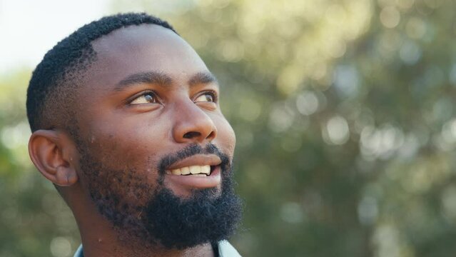 Close up of smiling man outdoors in countryside relaxing closing eyes and taking deep breaths of fresh air - shot in slow motion