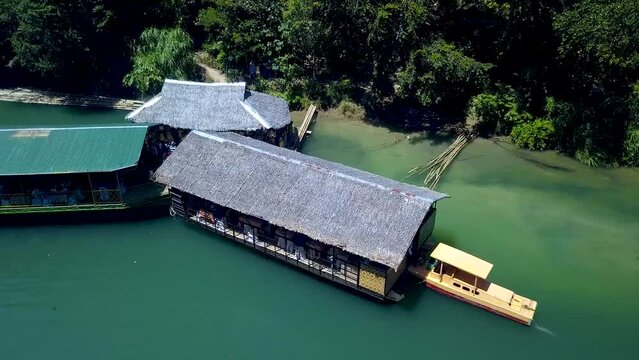A tourist boat and floating restaurant parked at the emerald green river in Loboc, Bohol, Philippines.