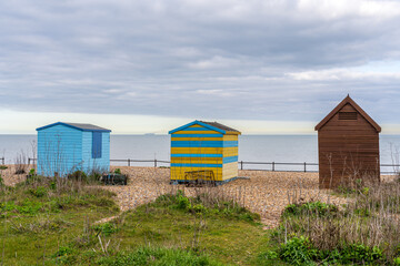 Fototapeta na wymiar Three beach huts overlooking the sea in Kingsdown, Kent, England