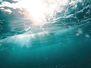 Fototapeten Close up underwater photo of giant waves in the middle of the ocean with bright sunlight breaking through them, turquoise color of water © shooreeq