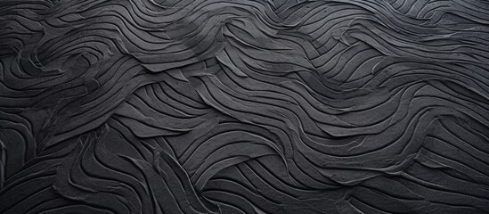 A close-up view of a smooth black surface displaying detailed and meandering wavy lines - obrazy, fototapety, plakaty