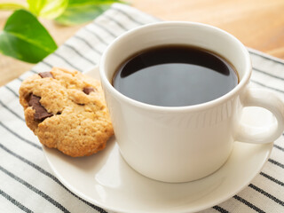 白いカップに入ったホットコーヒーとチョコクッキー