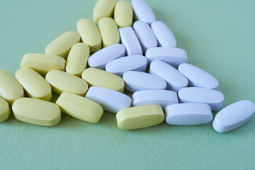 Multicolored tablets on green background. Accent on the foreground.