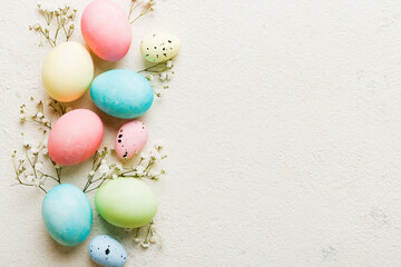 Happy Easter composition. Easter eggs on colored table with gypsophila. Natural dyed colorful eggs...