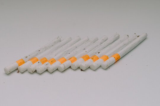 several kretek cigarettes lined up on a white base