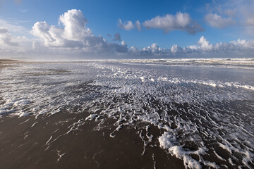 Sand beach with waves and foam. Bandon beach. Oregon. USA