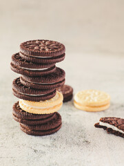 A stack of Oreo cookies with a vanilla sandwich cookie in the middle and a half-eaten cookie next to it.