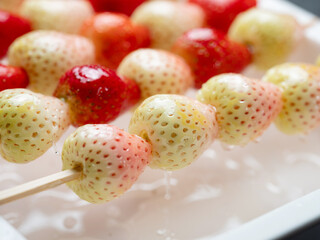 tanghulu, A food made by stringing fruits such as strawberries through bamboo and coating the...