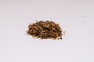 Fototapeta na wymiar Brown colored cigarette tobacco with a slightly wet texture is ready to be made into several cigarettes for mixing.
