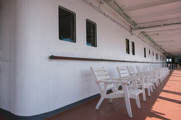 Covered teak promenade deck with chairs and recliners onboard historic ocean liner cruiseship...