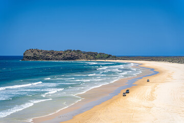 Scenic views looking towards Indian Head, with 4x4 vehicles driving on K'Gari, Fraser Island,...
