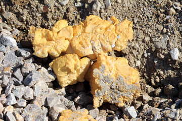 Chunks of used old Polyurethane foam or PU foam specialist material used for thermal insulation based on polyurethane chemistry left on gravel and stones at local construction site on warm sunny