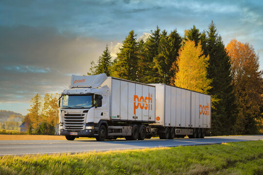 White Scania G490 truck and trailer for the deliveries of Finnish Post, Posti Group Oyj on the move at beautiful autumn sunset in Finland. 