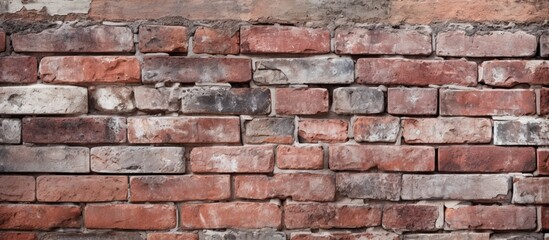 Obraz premium Brick wall with weathered texture seen up close next to a traditional red and white fire hydrant on a city street corner
