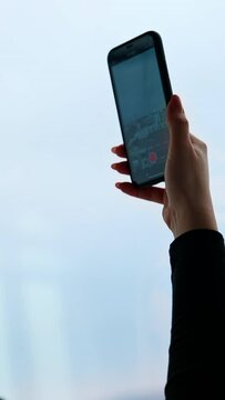 A beautiful smiling woman wearing eyeglasses is using a phone Vertical video