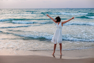 Happy traveler girl in a white summer dress enjoying a tropical paradise beach with turquoise sea. - 776953177