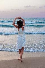 Happy traveler girl in a white summer dress enjoying a tropical paradise beach with turquoise sea. - 776953353