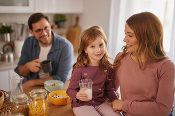 Happy family having breakfast at table in kitchen