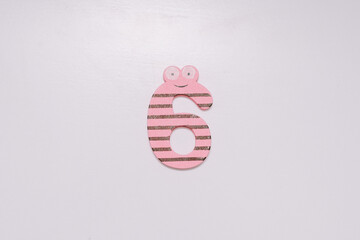 The number 6 in a cute children's number typeface is placed on a white base