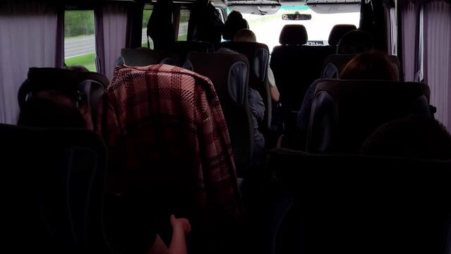 Passengers travel in an intercity minibus outside the city, view from the inside. Relocation and travel concept.