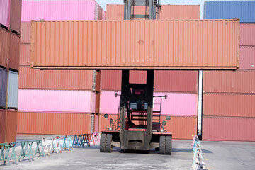 Forklift truck handling cargo, container boxes in logistics shipping yard with pile of cargo containers