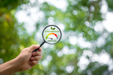 Magnifying glass measures net zero emissions with green area search for fresh air carbon neutral,...