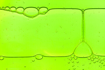 Liquid gel or serum on a screen of microscope lime green  reflected background with bubbles