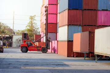Forklift truck handling cargo, container boxes in logistics shipping yard with pile of cargo containers