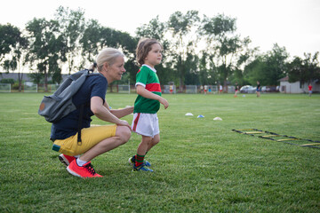 Mom with her son on the soccer field. A parent cares and encourages his child.