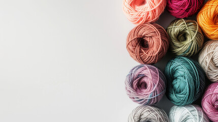 A colourful array of yarn spools on a white backdrop for crafting.