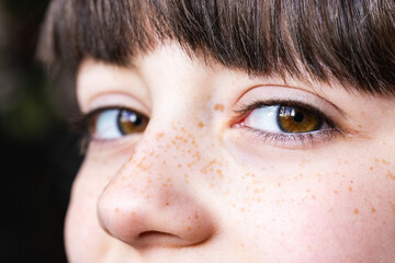 Close-up of child's freckled face with expressive eyes - 776990193