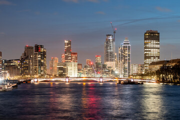 Panoramic view of London's skyline and thames river aglow with city lights at dusk - 776991338