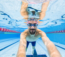 Underwater view of smiling swimmer in pool - 776991957