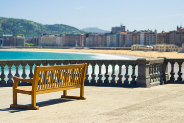 Fototapeta premium Wooden bench at promenade Beach of La Concha in San Sebastian, Basque country, Spain